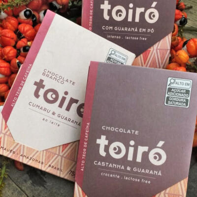 Embalagem de chocolate da marca Toiró pocisionado ao lado de sements de Guaraná.