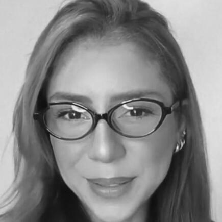 depoimento-gabrielle-azevedo-psicologa-omicha.jpg Retrato da psicóloga Gabrielle Azevedo, uma mulher jovem de cabelos avermelhados longos, usando óculos, sorrindo suavemente para a câmera em depoimento para a OMICHA.